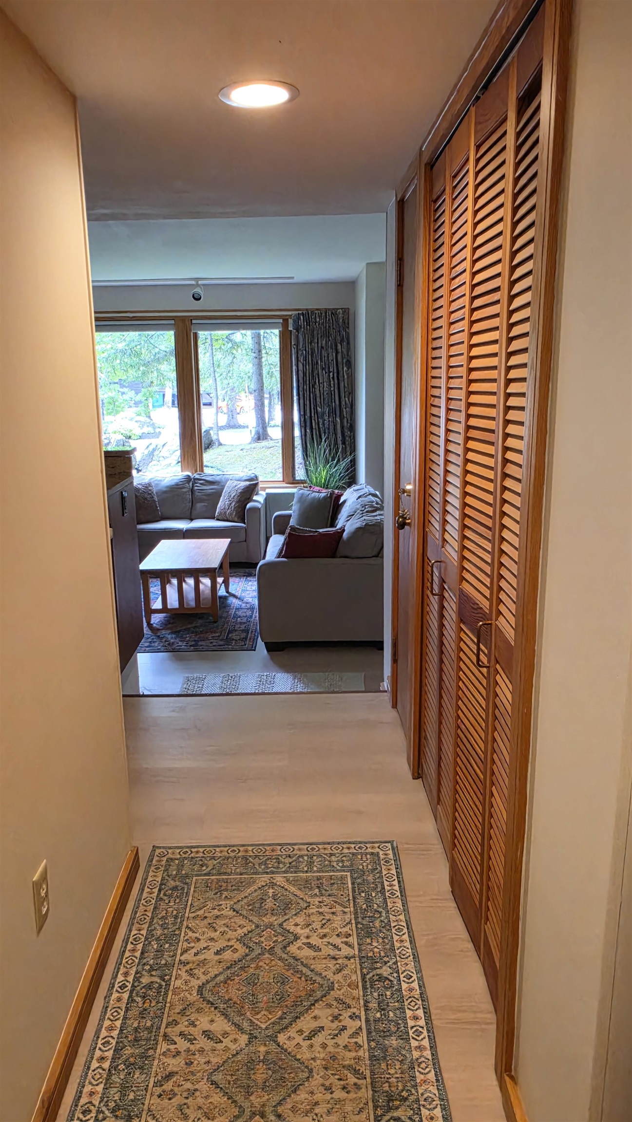 Hallway leads to kitchen, living, and dining areas