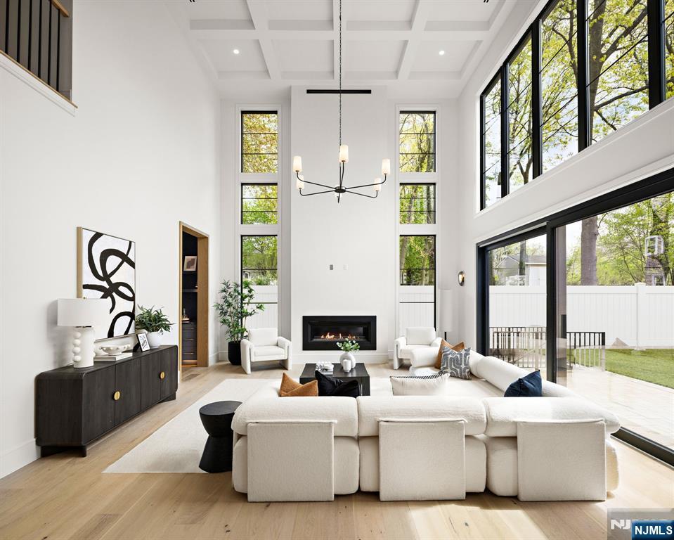 The adjoining family room offers soaring ceilings, a sleek fireplace, and seamless indoor-outdoor flow