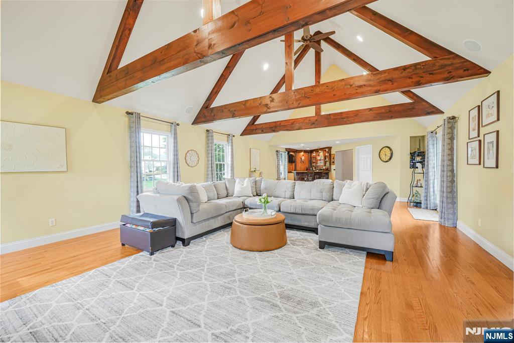 Originally a cape and thoughtfully transformed, this spacious home features a dramatic great room with exposed beams, soaring ceilings, wood-burning fireplace with gas ignitor, and full entertaining bar with sink and under-counter beverage refrigerator. H