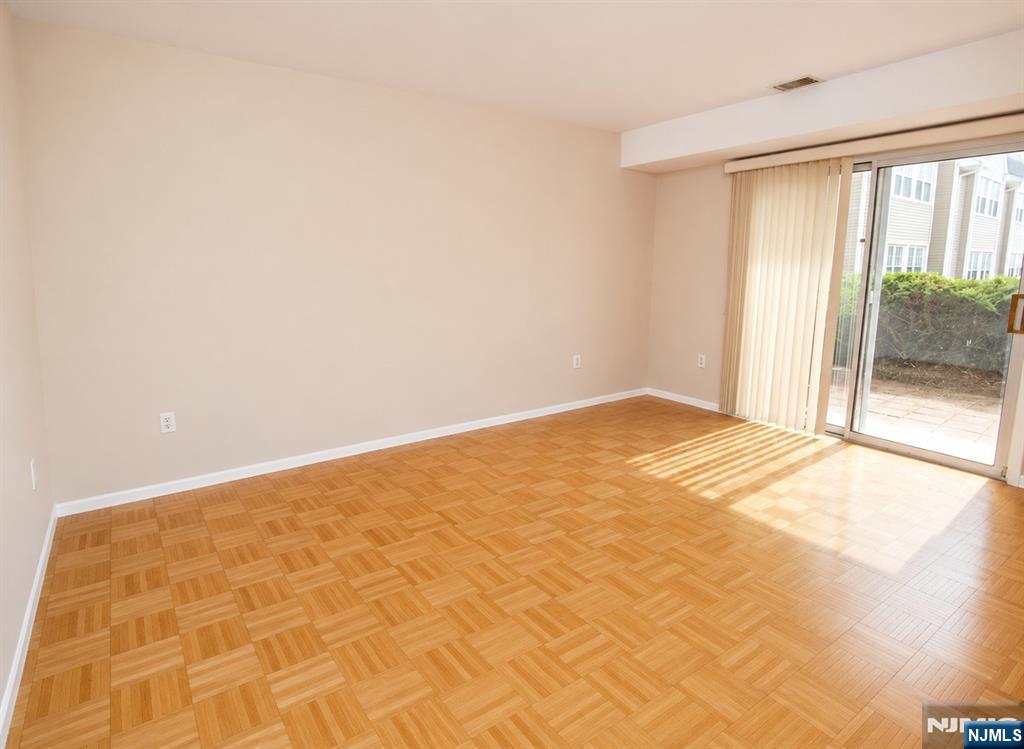 Primary bedroom, furniture and rug virtually removed, parquet floor added