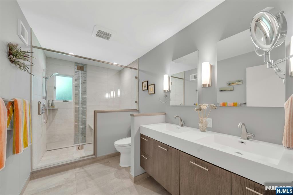 Spa-like primary bath with double sinks and deep soaker tub seamlessly integrated into the walk-in shower